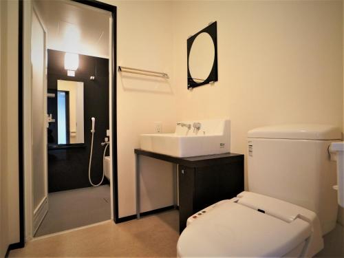 uma casa de banho com um WC branco e um lavatório. em Green Rich Hotel Tosu Ekimae em Tosu