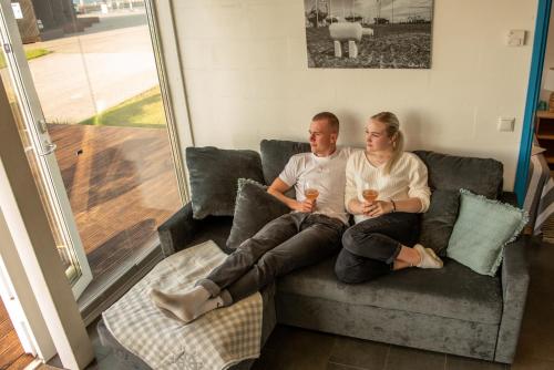 a man and a woman sitting on a couch at Merevaatega majutus Kärdla sadamas in Kärdla
