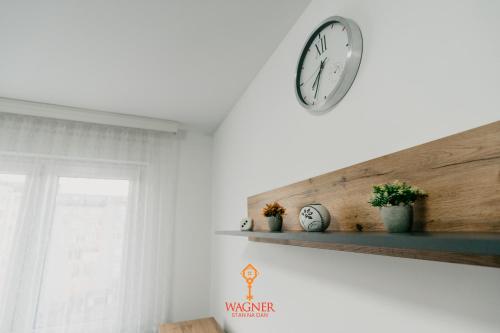 a clock on a wall next to a window at Apartman Wagner in Bugojno