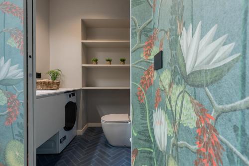 uma casa de banho com WC e uma parede com flores em Green Luxury Apartment by Wonderful Italy em Turim