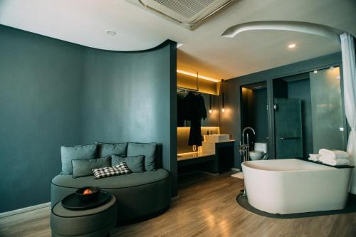 a bathroom with a bath tub and a sink at foto Hotel Phuket in Phuket Town