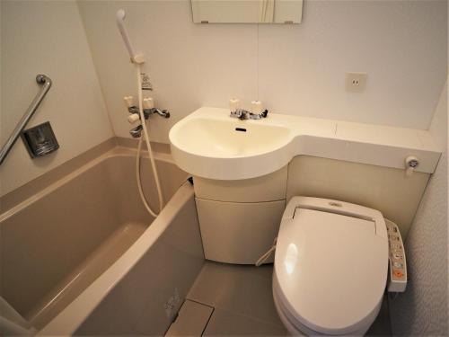 a small bathroom with a toilet and a sink at Green Rich Hotel Tosu Ekimae in Tosu