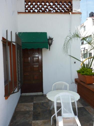 a table and two chairs in front of a door at Hotel Bajo el Volcan in Cuernavaca