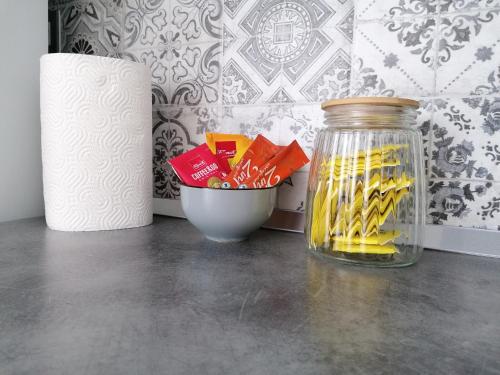 a jar of candy on a table next to a bowl of candy at Apartman Enio in Vukovar