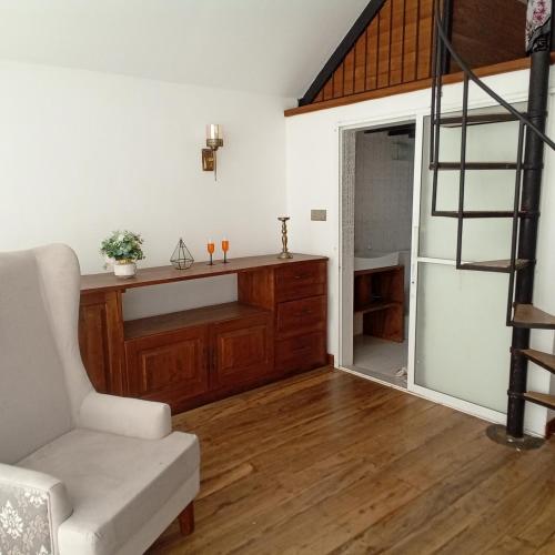 a living room with a staircase and a white couch at Bird Nest - Hanthana in Kandy