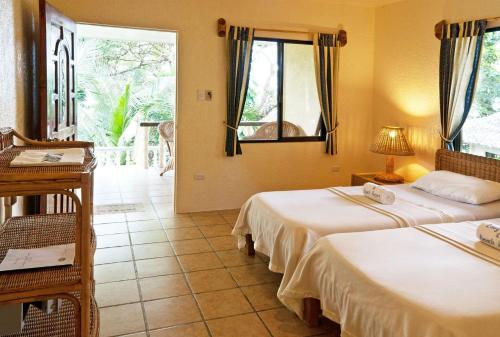 錫帕萊的住宿－易潛海灘度假村，一间卧室配有两张床、一张桌子和一面镜子
