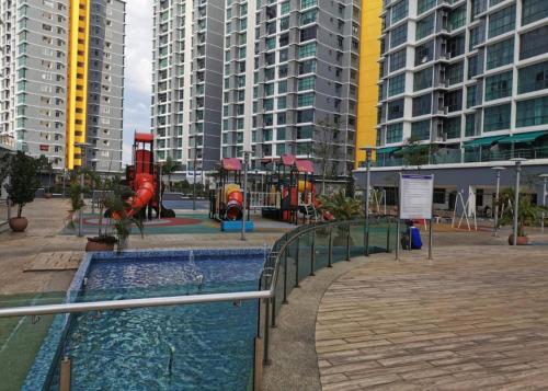 einen Spielplatz mit Rutsche in einer Stadt mit hohen Gebäuden in der Unterkunft Vista Alam in Shah Alam