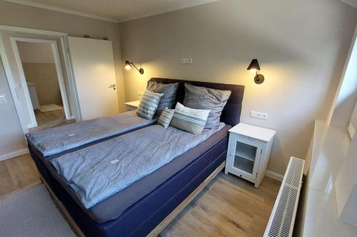 a bedroom with a large bed with blue sheets and pillows at Ferienwohnung De ole School mit eigener Sauna! in Fehmarn