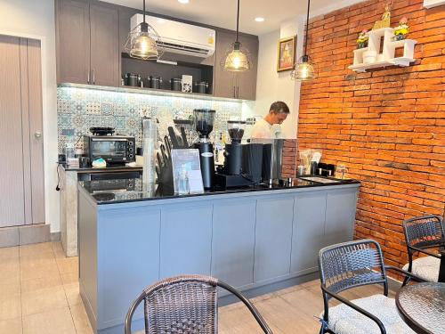 a man standing behind a counter in a kitchen at Aree House Poshtel in Pattaya South