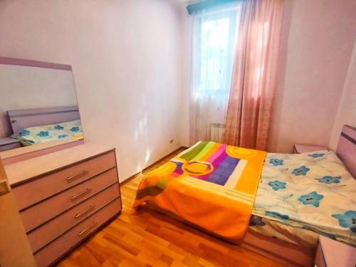 een kleine slaapkamer met een bed en een dressoir bij Sevan Island Cottage in Sevan