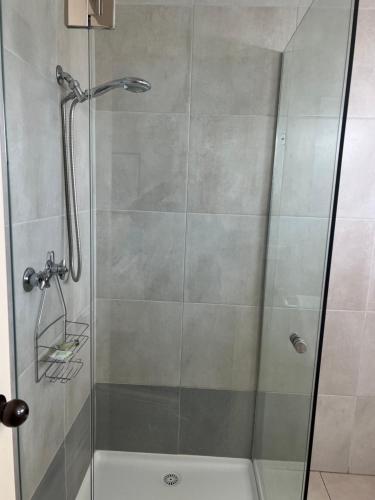 a shower with a glass door in a bathroom at Woodmans Hill Motel in Ballarat