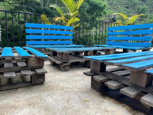 a group of blue benches sitting next to a fence at Artomoro Ceylon motel in Demodera