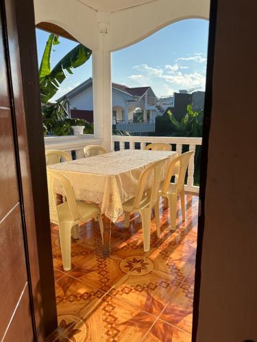 a table and chairs on a porch with a view of a house at Cebu City 3 bedrooms split house 2nd floor-WIFI in Cebu City