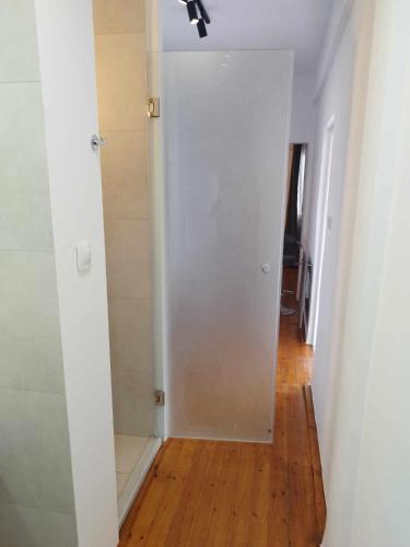 a hallway with a white door and a wooden floor at Petmeza Top Aigio City F in Aígio