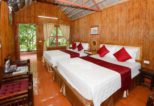 - une chambre avec 2 lits et des oreillers rouges dans l'établissement Tam Coc Garden Homestay, à Ninh Binh
