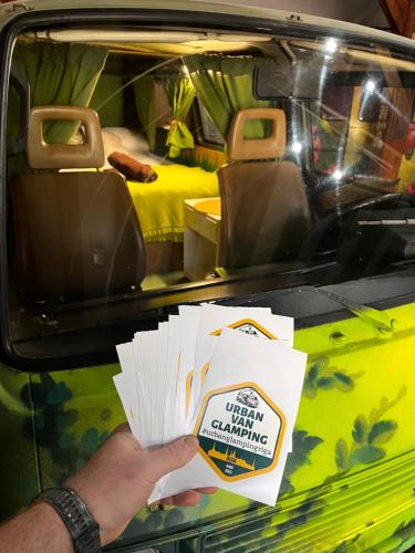 a person holding up cards in the back of a car at Urban Van Glamping Riga in Rīga