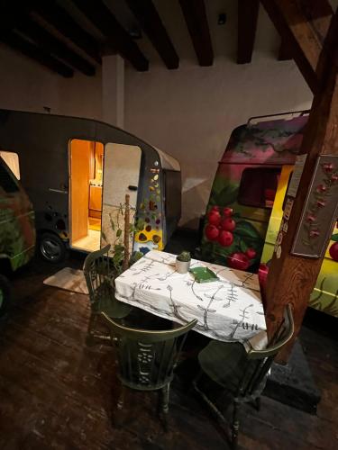 a table and chairs in a room with a caravan at Urban Van Glamping Riga in Rīga