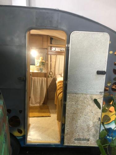 an open door of a trailer with a bed in it at Urban Van Glamping Riga in Rīga