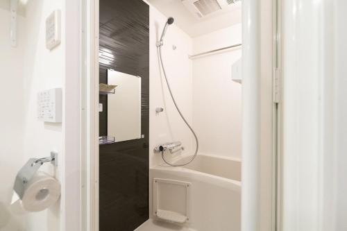 a bathroom with a shower and a toilet and a tub at Apiche Oji in Tokyo