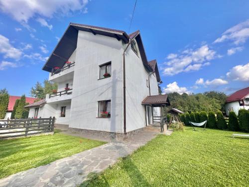 a white house with a black roof at Villa NOVA Cozy and Modern -5 min from center in Bran