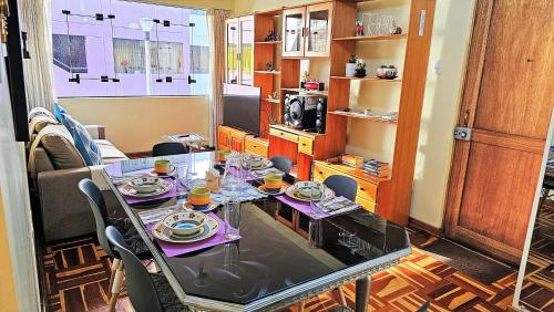 une salle à manger avec une table et de la vaisselle dans l'établissement Kuntur Wasi: Super Cómodo, iluminado y céntrico, à Cusco