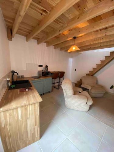 Il comprend un salon avec deux chaises et une cuisine. dans l'établissement Petite maison de village, à Ébreuil