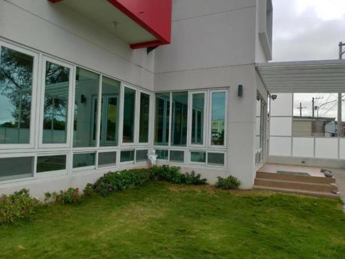 a white house with glass windows and a yard at King X.S. B&B in Taitung City