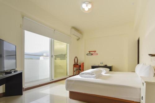 a bedroom with a large bed and a large window at King X.S. B&B in Taitung City
