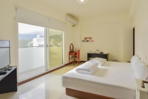 a bedroom with a large bed and a large window at King X.S. B&B in Taitung City