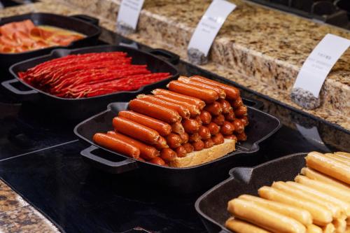 a display of hot dogs and hot dogs in pans at Hilton Shigatse in Shigatse
