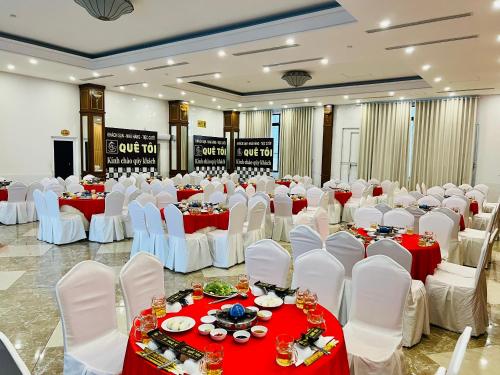 una sala banchetti con tavoli e sedie rossi e bianchi di Quê Tôi 2 Hotel a Soc Trang