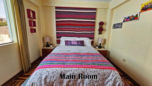 a bedroom with a bed with a striped wall at Kuntur Wasi: Super Cómodo, iluminado y céntrico in Cusco