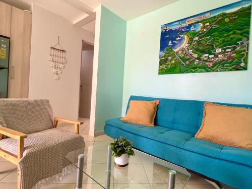 a living room with a blue couch and a chair at Coco Dream Escapes Ground Unit in Coco