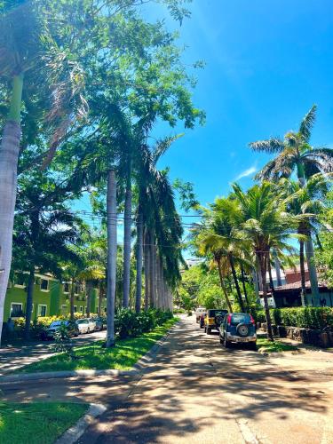 a street with palm trees and cars parked on the street at Coco Dream Escapes Ground Unit in Coco