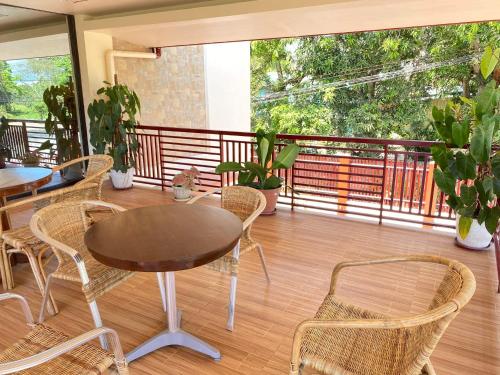 Habitación con balcón con mesa y sillas. en Tessie's Home Stay Bed & Breakfast en Puerto Princesa