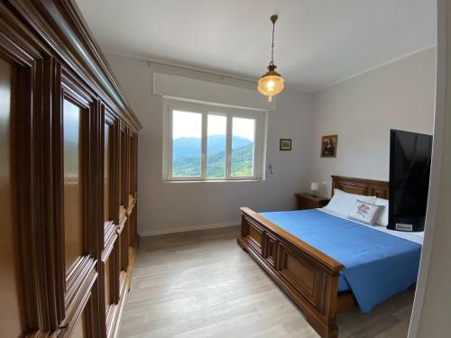 Schlafzimmer mit einem Bett, einem TV und einem Fenster in der Unterkunft Albergo Lodrino in Villa