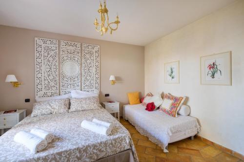- une chambre avec 2 lits et un lustre dans l'établissement Villa Provenzale Clos de Minerve, à Juan-les-Pins