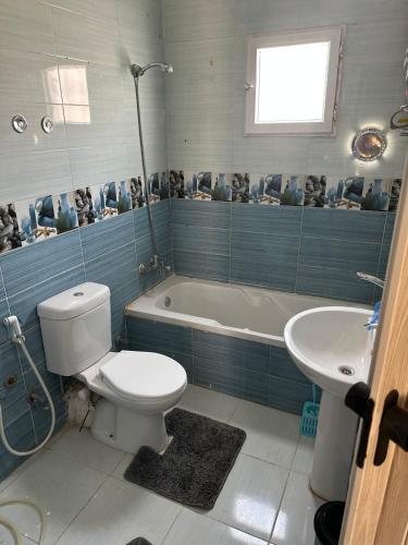 a bathroom with a toilet and a tub and a sink at Villa in a compound with a rooftop in sheikh zayed in Sheikh Zayed