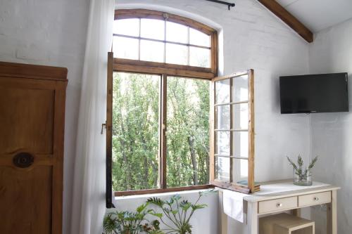 een open raam in een kamer met een televisie bij Kogman & Keisie Guest Farm in Montagu
