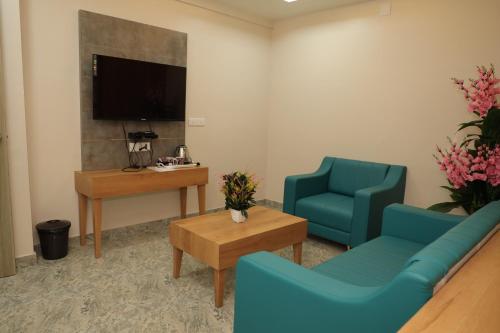 a waiting room with two blue chairs and a tv at Hotel Lord Krishna in Dwarka