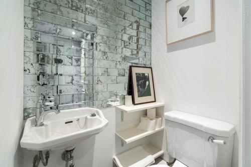 uma casa de banho branca com um lavatório e um WC em Stylish 2 bedroom at Hammersmith em Londres