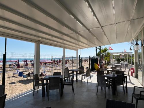 un restaurante con mesas y sillas y vistas a la playa en Villaggio Almar, en Vieste