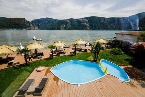 a swimming pool with a view of a body of water at Pensiunea Decebal Resort - Cazanele Dunarii in Dubova