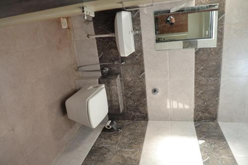 a bathroom with a white toilet and a mirror at Hotel Lord Krishna in Dwarka