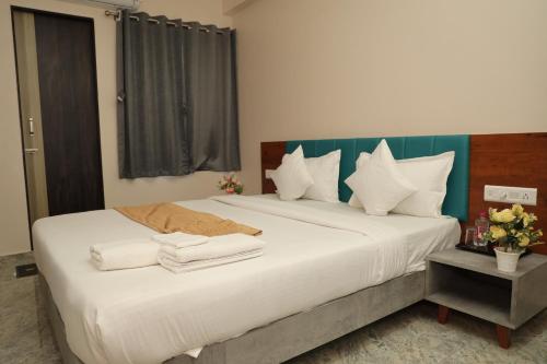 a hotel room with two beds with towels on them at Hotel Lord Krishna in Dwarka