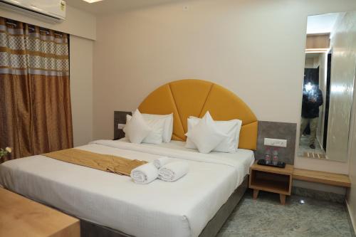 a bedroom with a bed with two towels on it at Hotel Lord Krishna in Dwarka