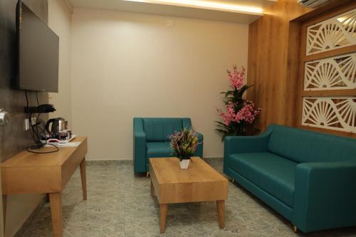 a living room with a couch and two chairs at Hotel Lord Krishna in Dwarka