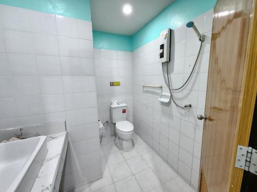 a bathroom with a toilet and a shower in it at Blue Beach Bungalow in Bang Saphan Noi