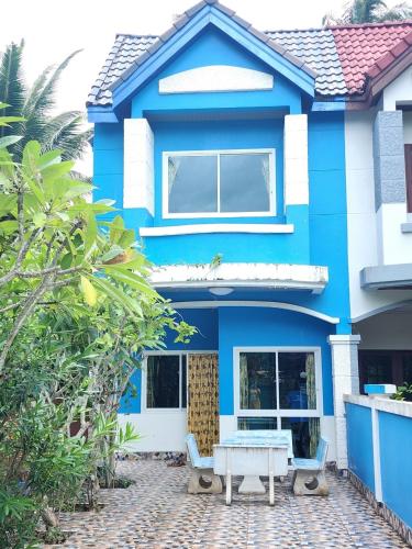 a blue house with a table in front of it at Blue Beach Bungalow in Bang Saphan Noi