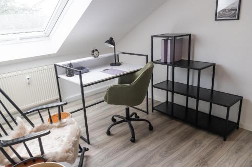 a desk and a chair in a room with a window at fuldaliebe - Klimatisierte moderne Ferienwohnung in Fulda in Fulda